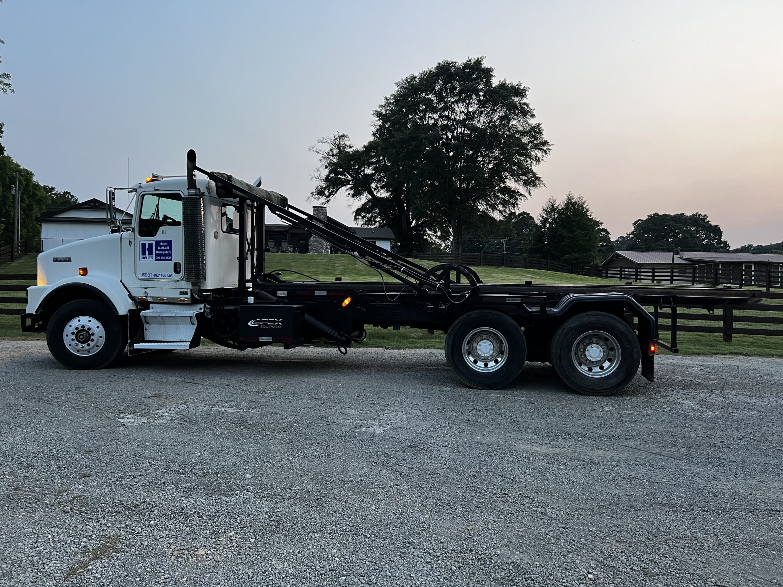 Hales Roll-off truck loading a 40-yard dumpster container onto the truck.